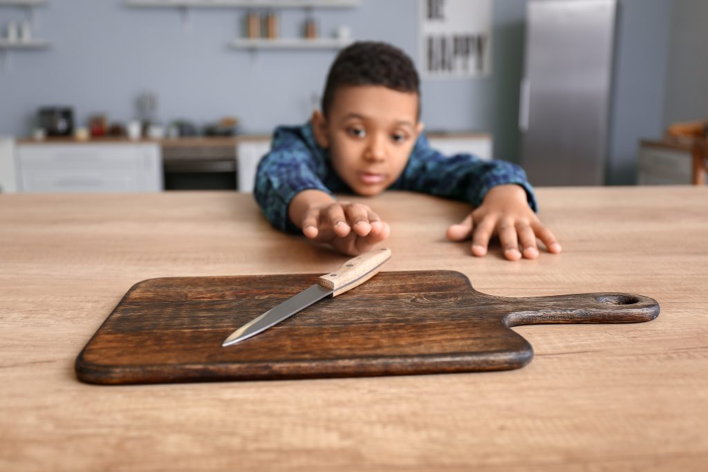 Little,African-american,Boy,Playing,With,Knife,In,Kitchen.,Child,In